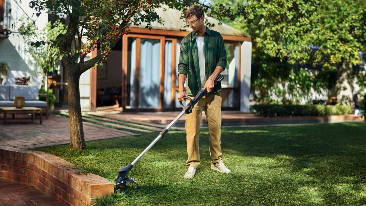 Man with aspire tool in backyard